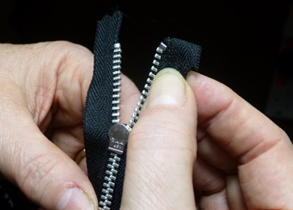 Hands holding zipper