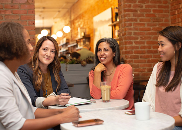 Group of women sitting at table talking