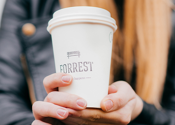 Person holding coffee cup with Forrest logo
