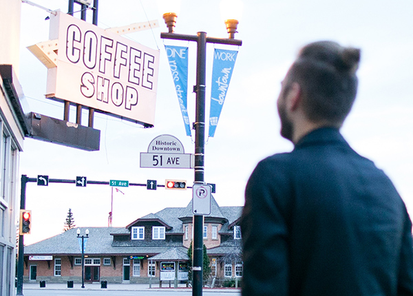Person walking towards coffee shop sign