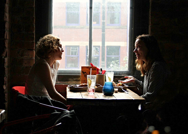 Two women talk at a table