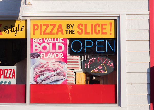 Pizza shop windows with signs and advertisements