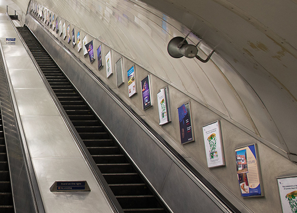 Long escalator with posters along the walls