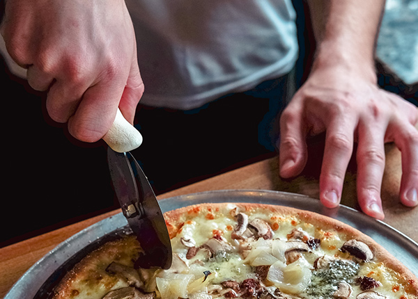 Person slicing pizza