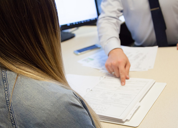 Two people at a desk doing paperwork