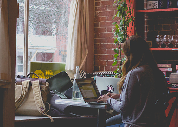 Woman typing on laptop in coffee shop