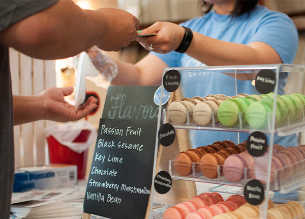 Worker and customer exchanging money and goods over a counter