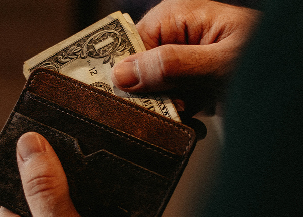 Hands taking money out of a wallet