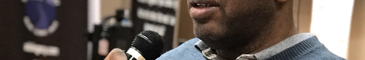 Chapter banner: man speaking into microphone