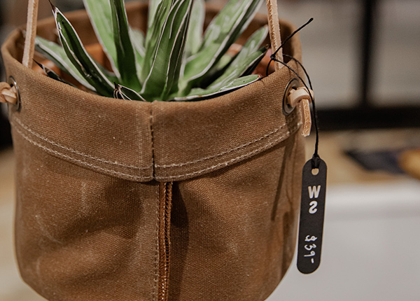 Hanging canvas bag with a plant in it with a $39 price tag