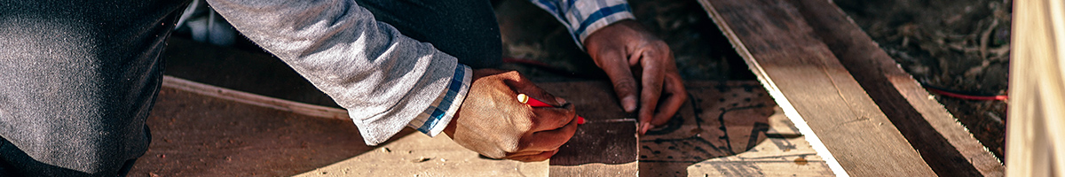 Chapter banner: Hands measuring pieces of wood at a construction site