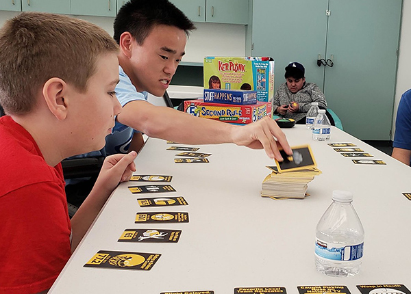 A group on young boys plays a card game