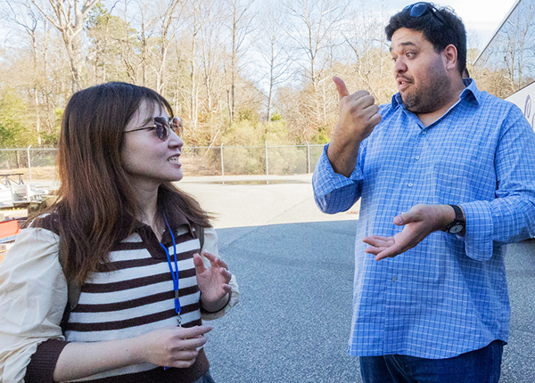 Two people standing outside talking animatedly