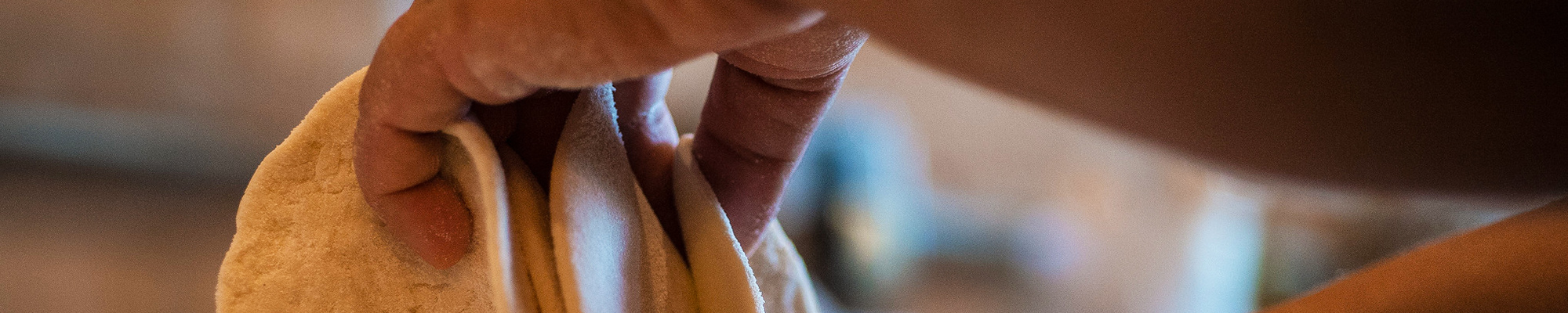Banner image: Close-up of hands holding small, round pizza crusts