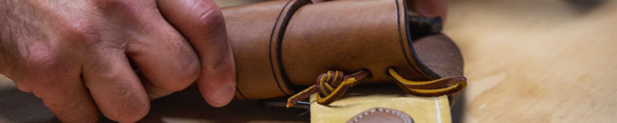 Banner image: Close-up of hands making a leather sheath
