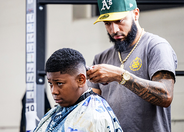 Man giving a teenage boy a haircut