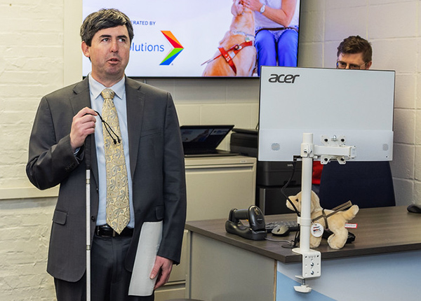 Man who uses a white cane standing in a business