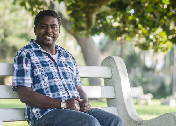 Man sitting on a park bench smiling