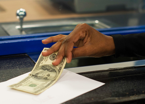 A hand grabbing a one hundred dollar bill