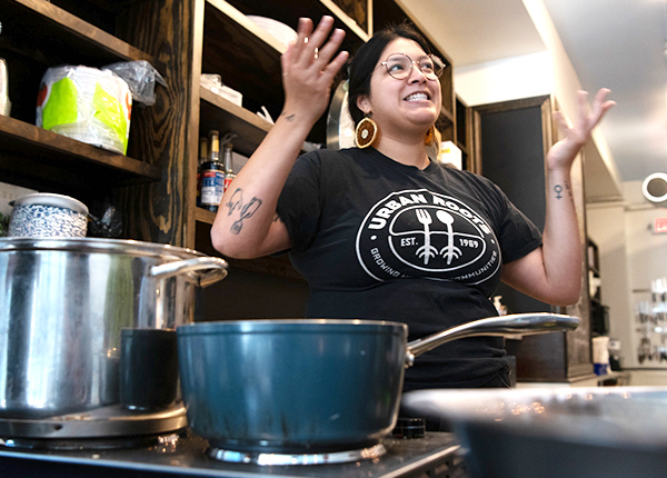 Person working in a kitchen with their hands up in the air in a questioning gesture