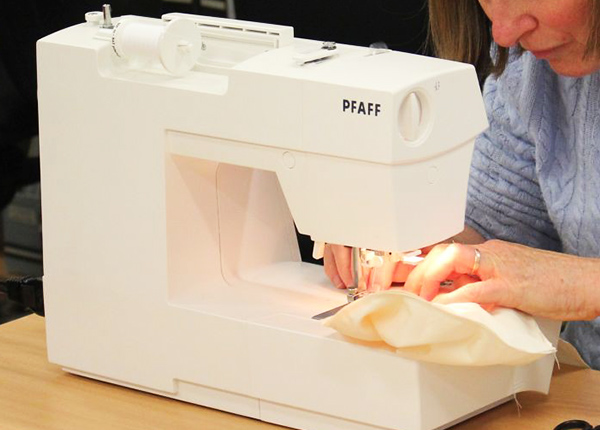 Person sewing on a sewing machine