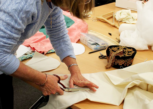 Person cutting fabric with scissors