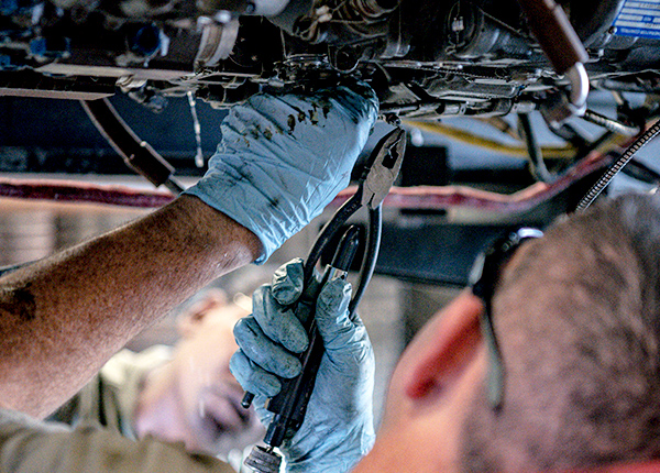 Mechanic using pliers to work on a machine