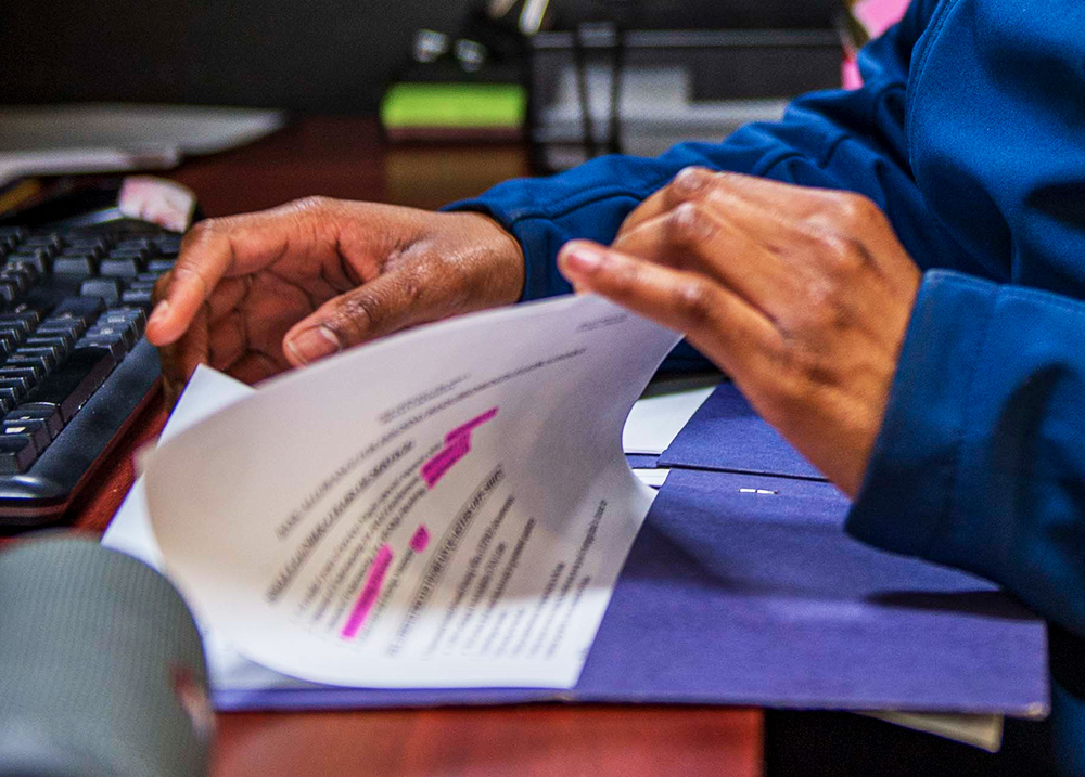 Person flipping through papers in a folder