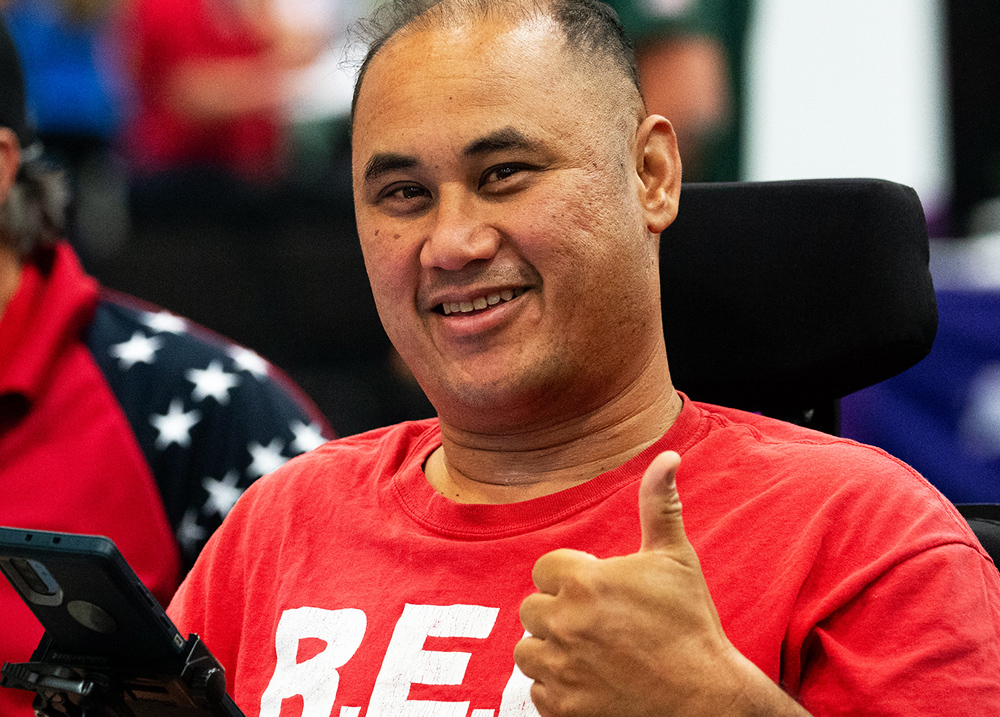 Man who uses a wheelchair giving a thumbs up