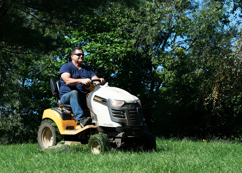 Person mowing a lawn with a riding mower