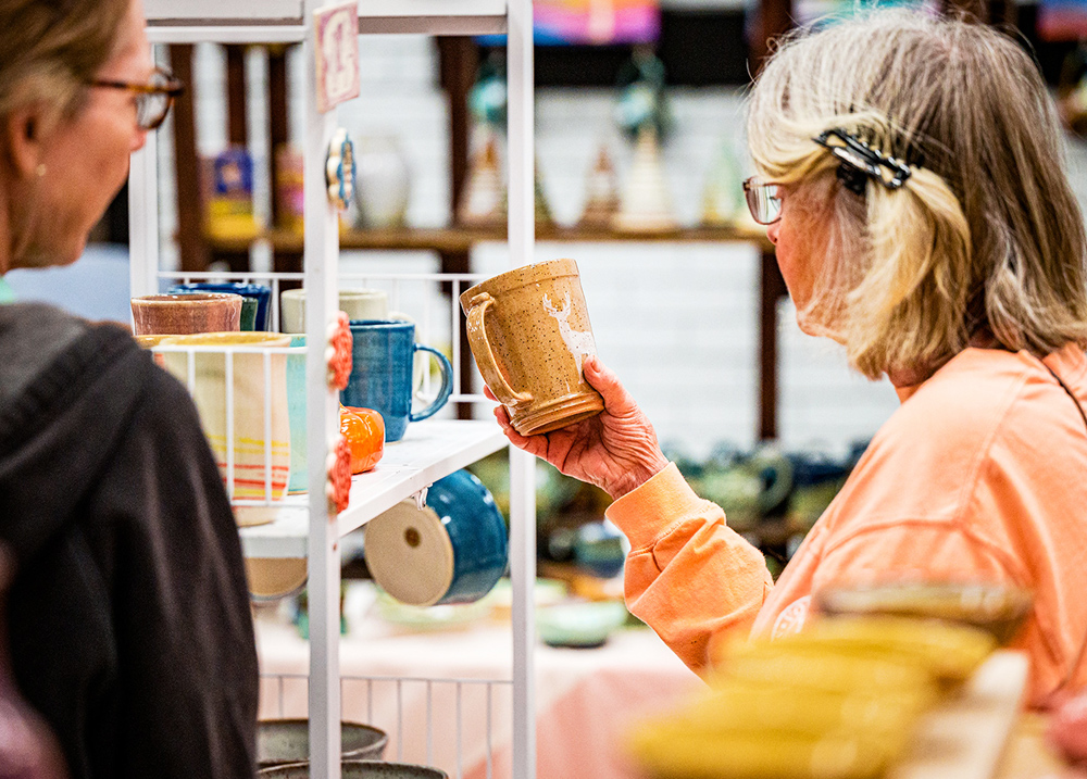 Two people looking at a ceramic mug