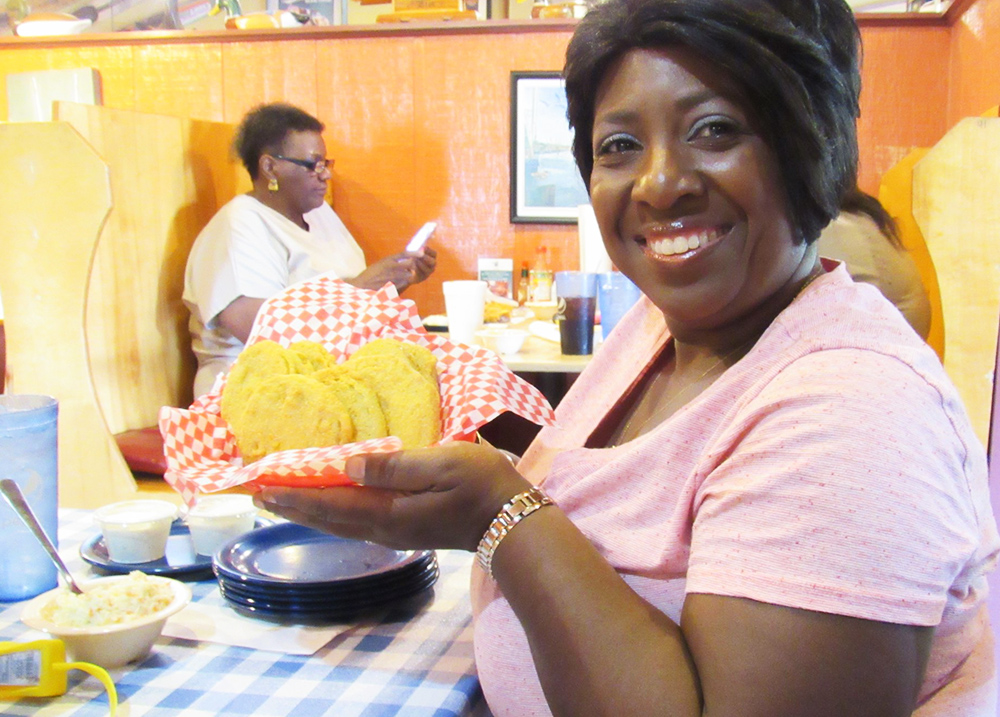 Woman holding up a basket of food at a restaurant