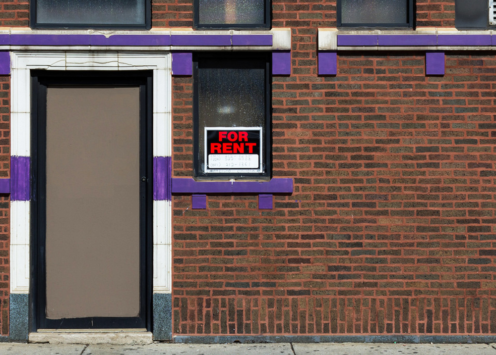 Building with a for rent sign in the window