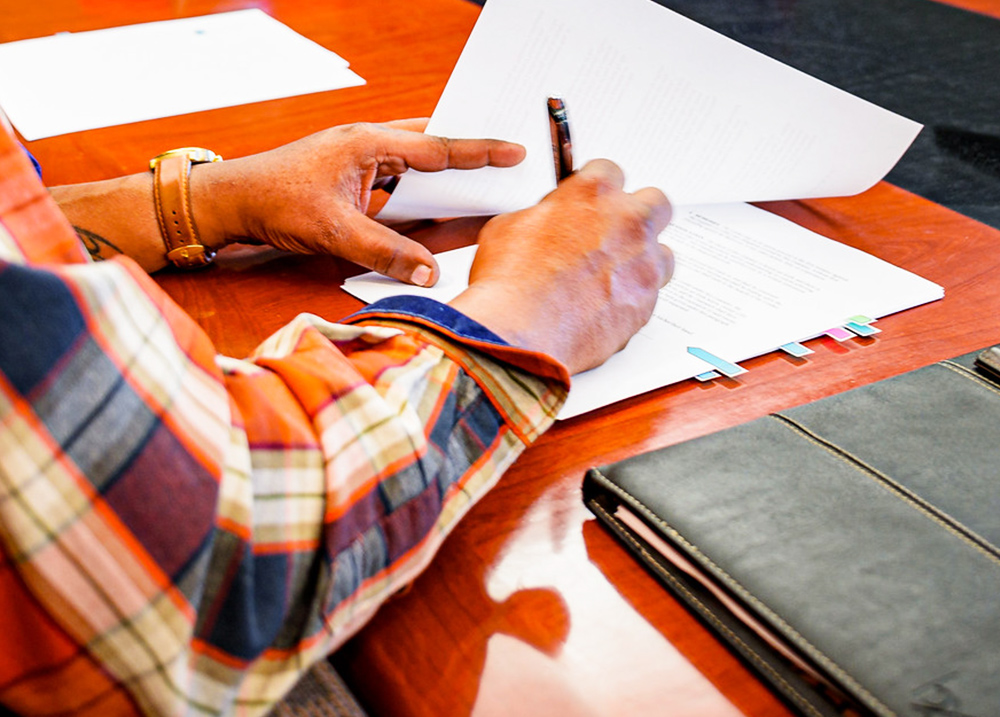 Person sitting down signing paperwork