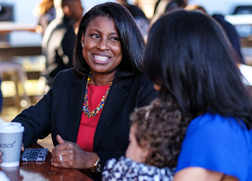 Two women, one with a child on her lap, engaged in conversation