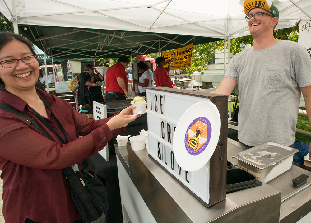 Person buying ice cream from a vendor at an outdoor market