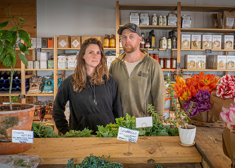 A young couple stands behind the counter at a business