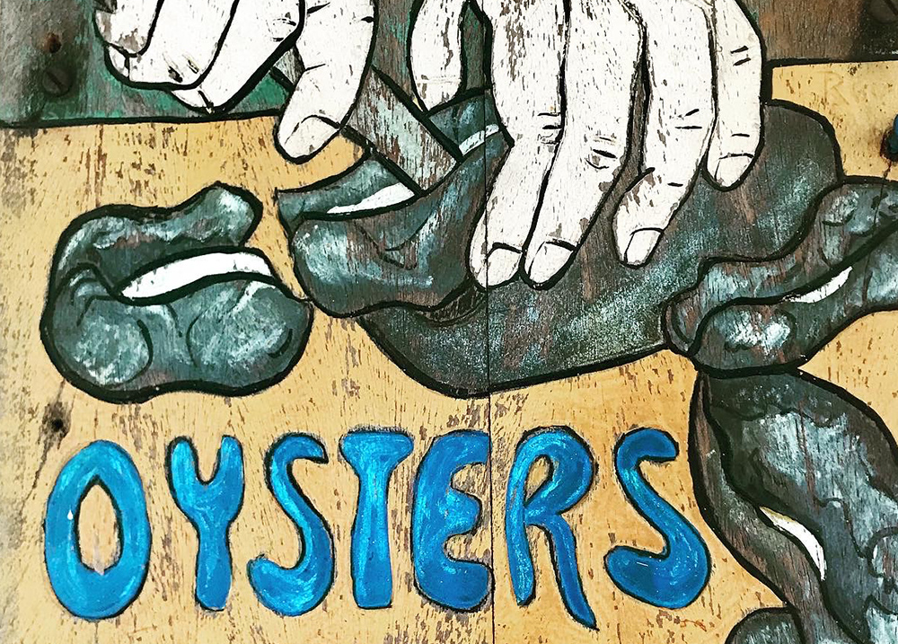 Hand-painted sign that says Oysters
