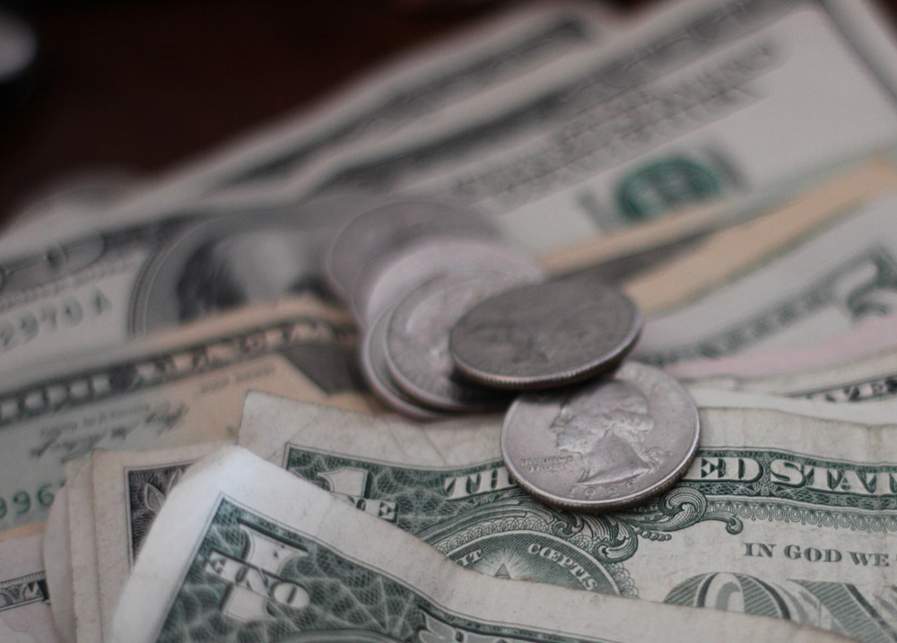 A stack of dollar bills and quarters