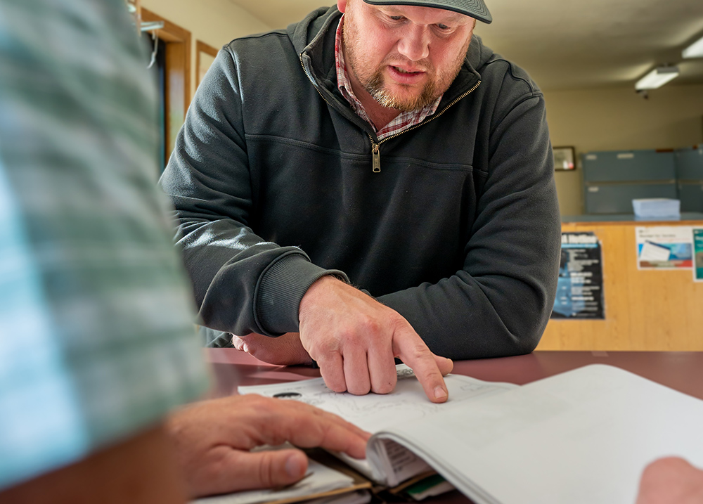 Man pointing at something in a notebook