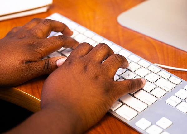 Close-up of hands typing on a computer keyboard