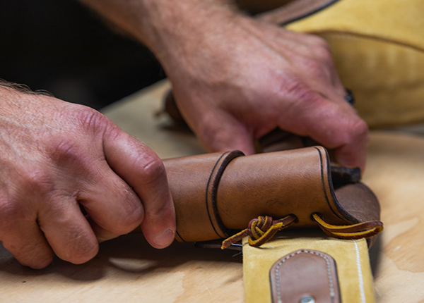 Close-up of hands making a leather sheath