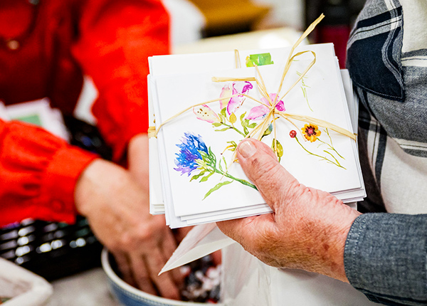 Close-up of a hand holding a hand-painted card