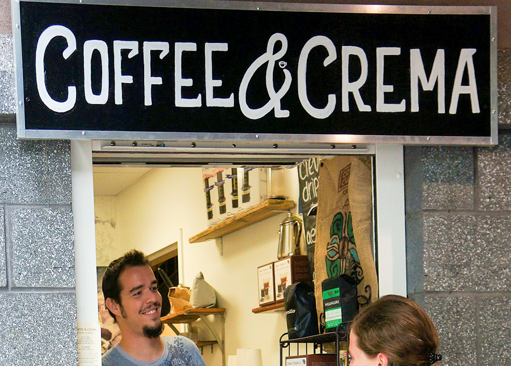 Coffee shop with sign that says Coffee & Crema