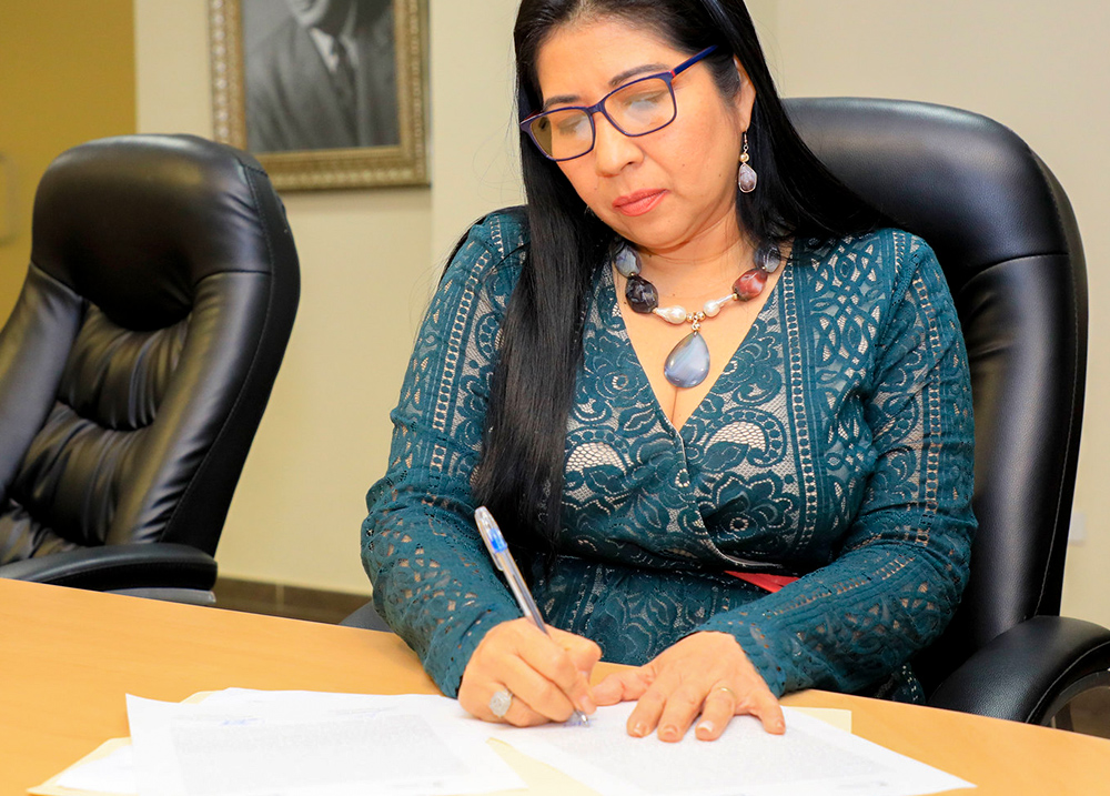 Woman sitting at desk writing on papers