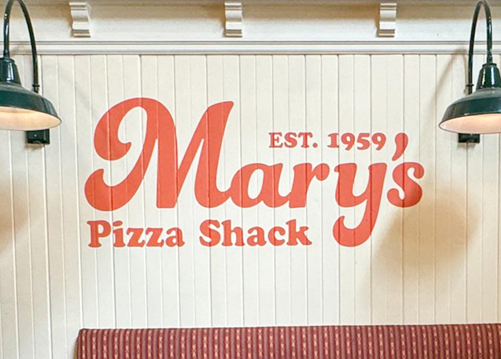 A wall with a logo that says Mary's Pizza Shack