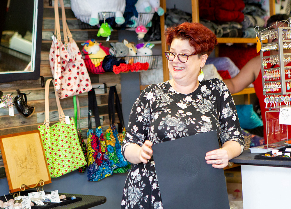 Woman leaning against a counter in a shop smiling