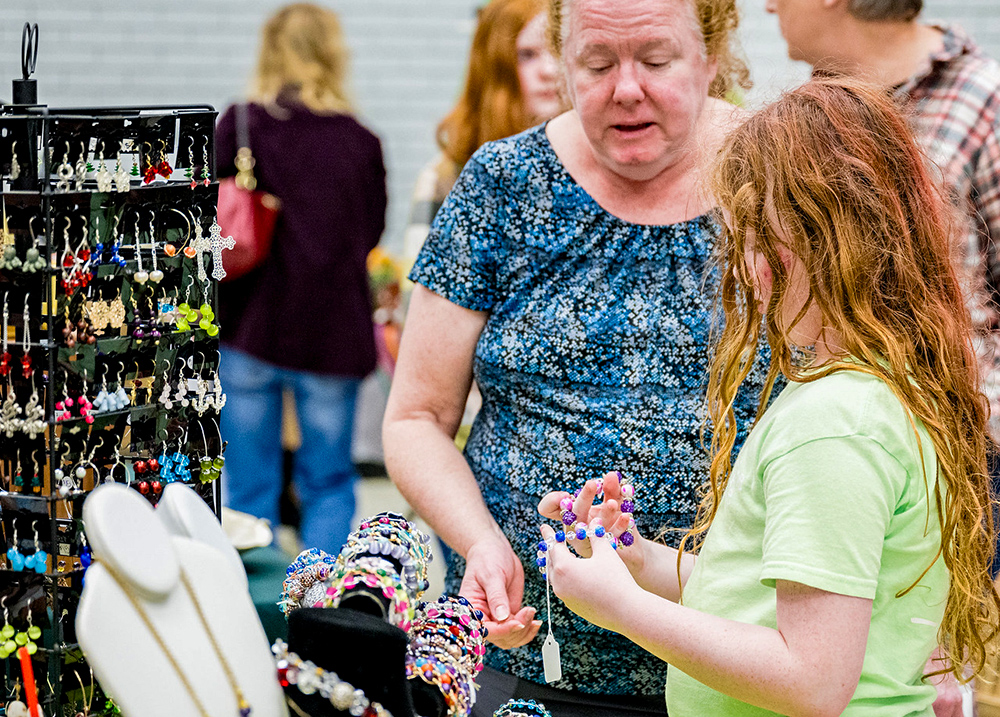 Two customers looking a jewelry at a craft fair