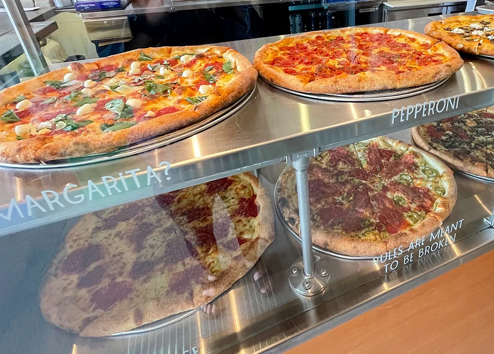 Pizzas on display in a glass case