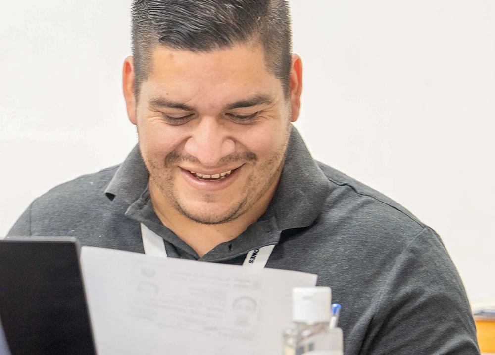 Man smiling down at a paper he's holding